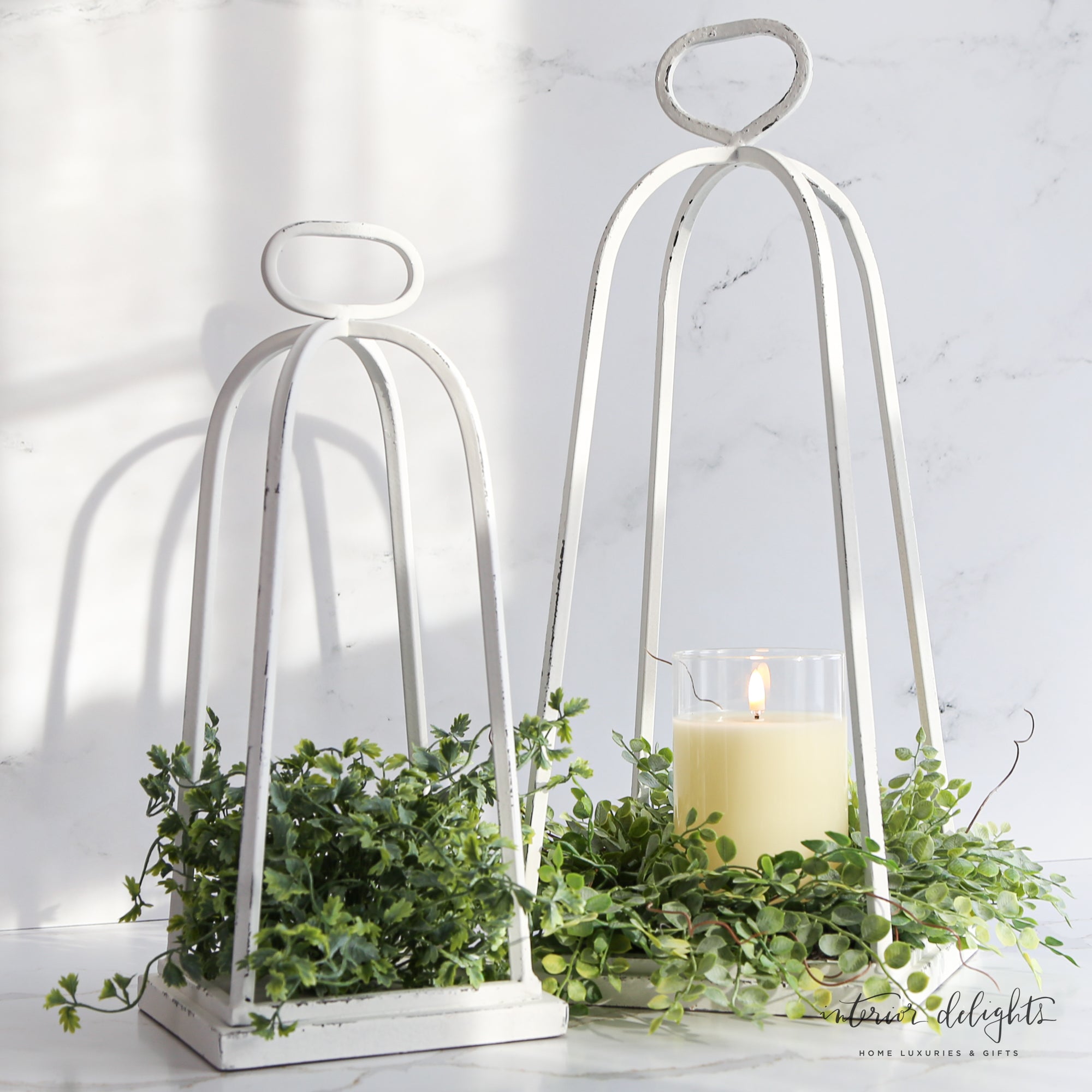 White Distressed Lanterns - Set of 2 placed on a tabletop, ideal for creating a cozy ambiance.