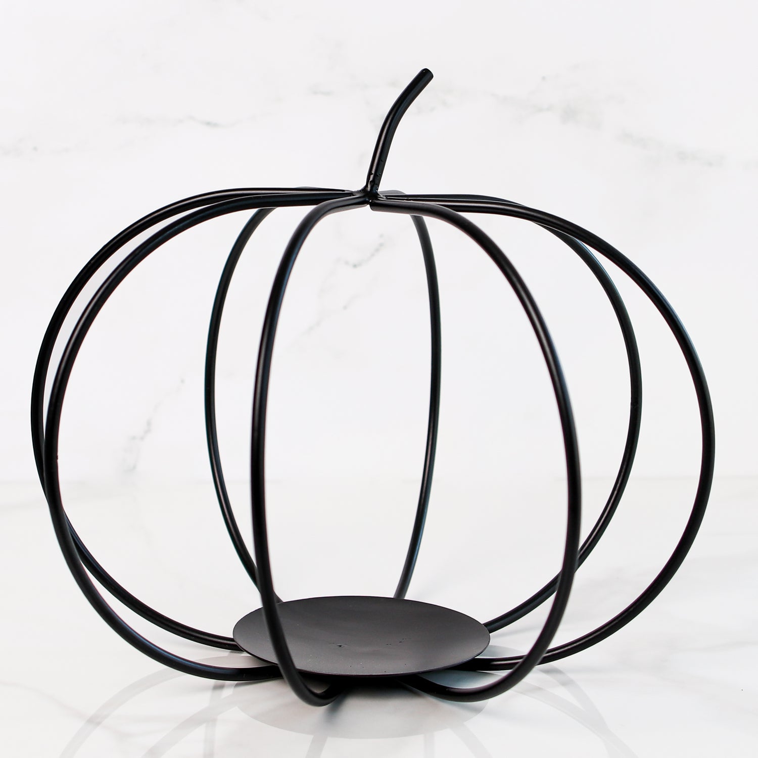 Large Black Metal Pumpkin displayed on a mantel as a cozy autumn accent for home decoration.