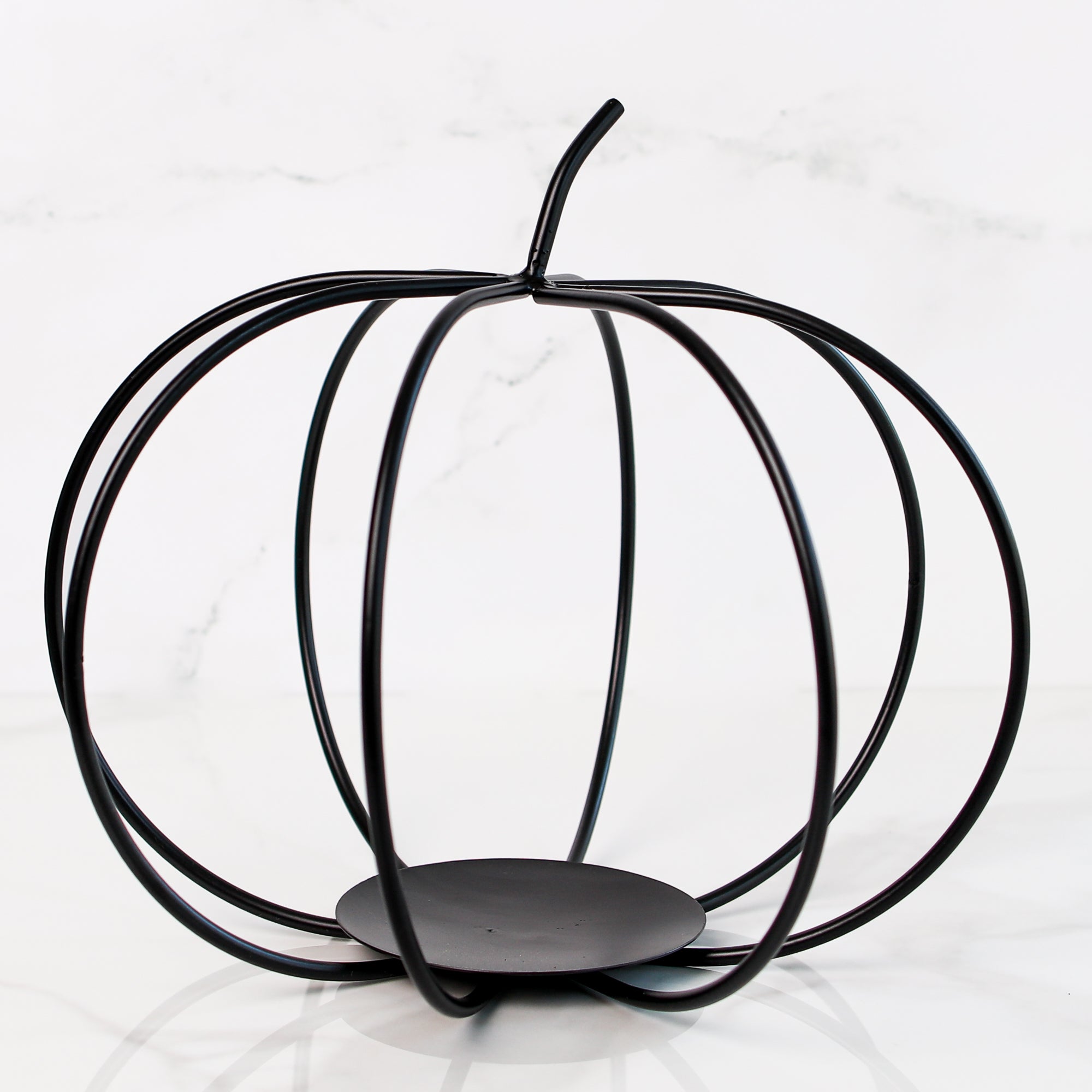 Large Black Metal Pumpkin displayed on a mantel as a cozy autumn accent for home decoration.