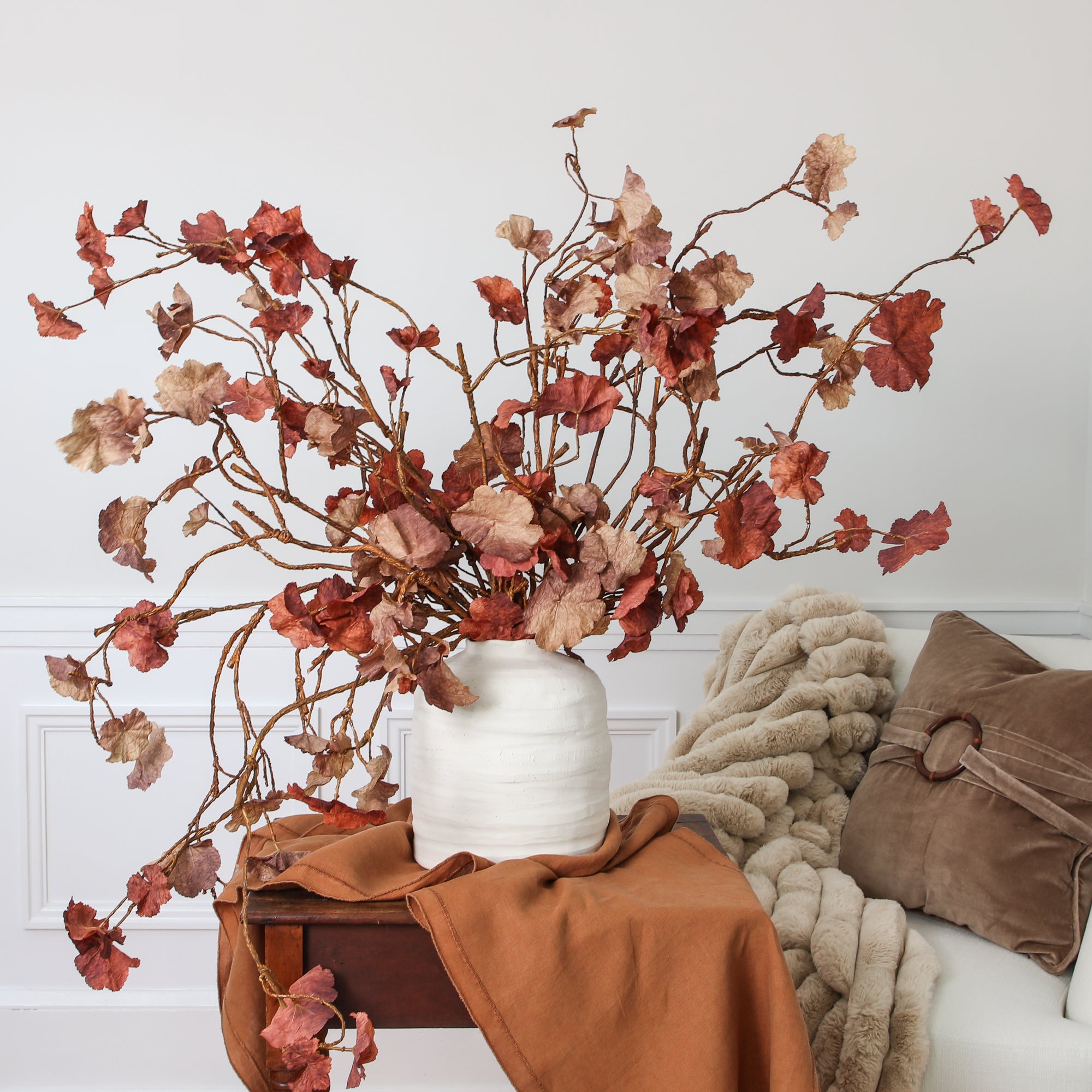 10.5” Ivory Stoneware Vase showcasing its unique hand-shaped silhouette and artisan texture against a cozy cottage decor.