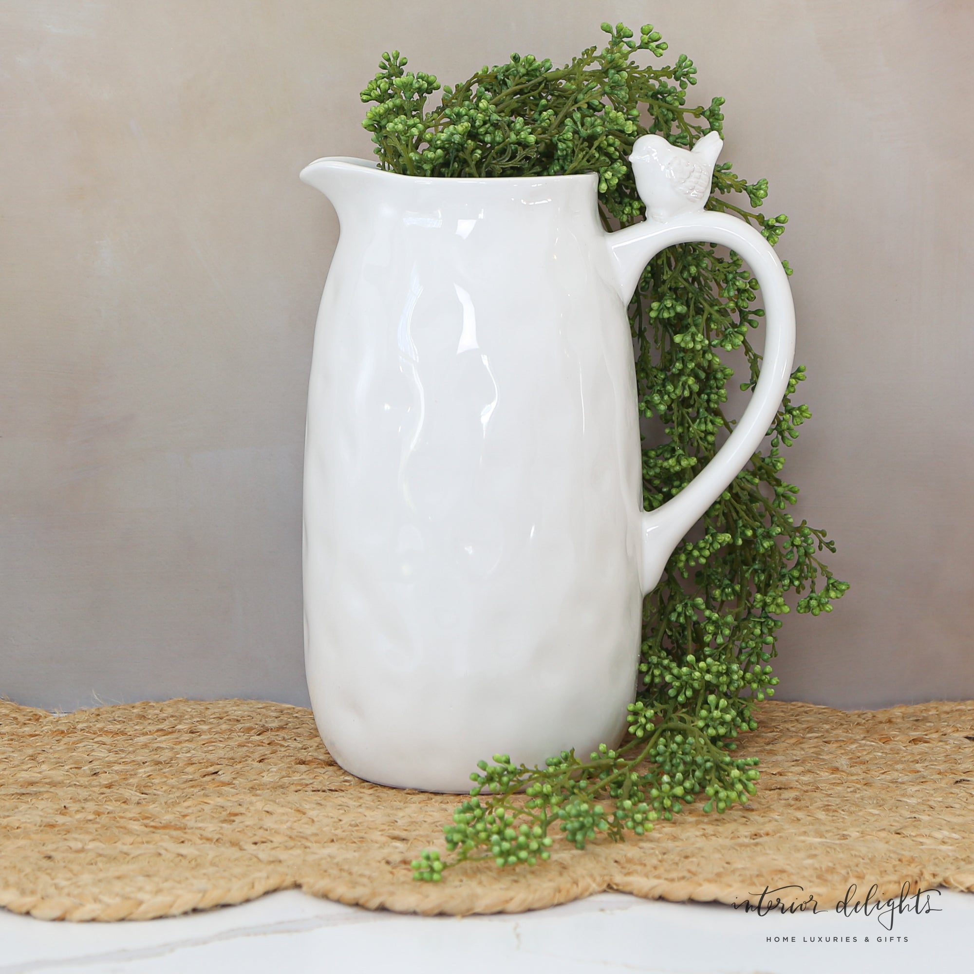 10” White Ceramic Pitcher with Bird, featuring a charming bird detail and hammered texture, perfect for serving drinks or displaying flowers.