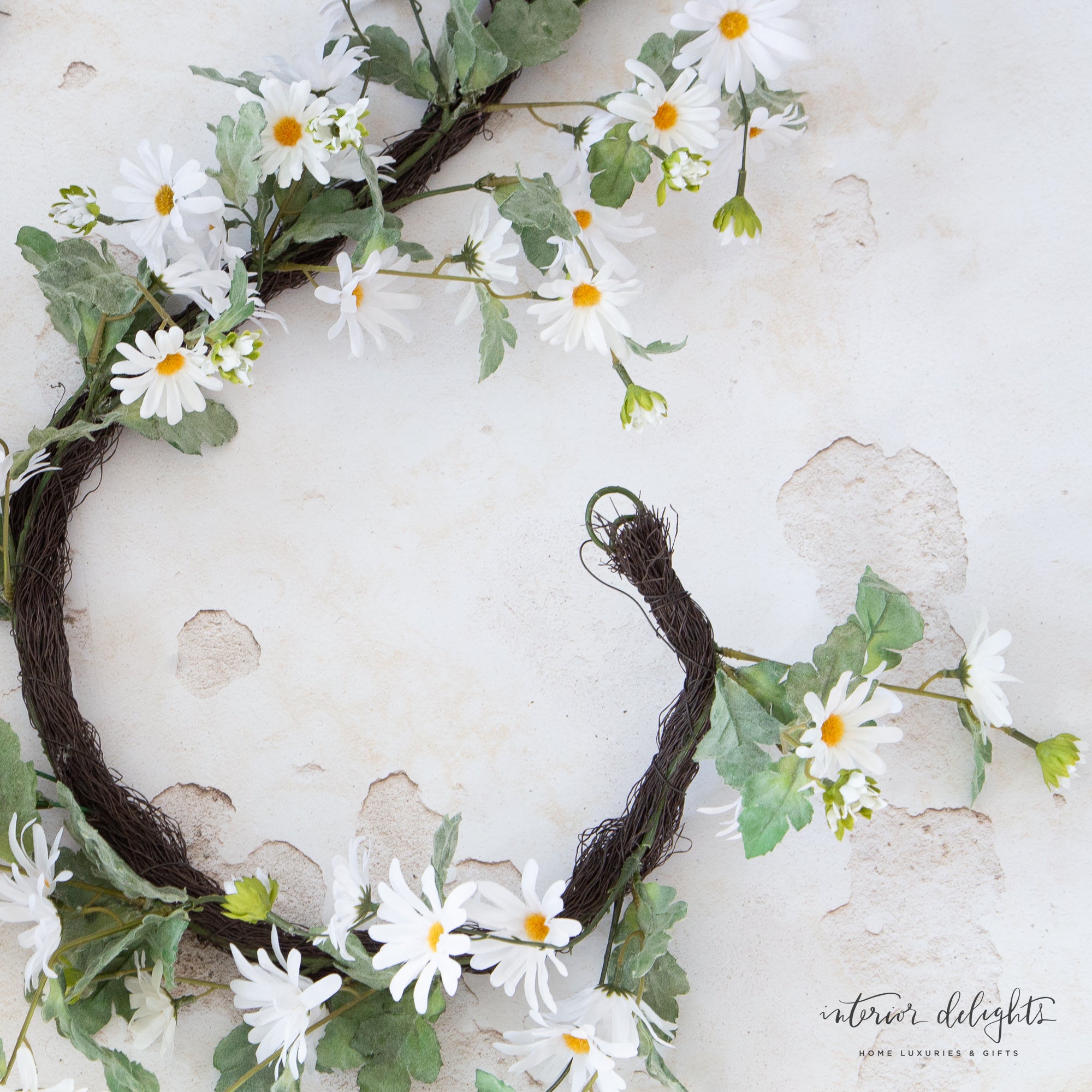 The 6-foot White Shasta Showers Garland draped elegantly over a mantel, showcasing its cheerful white daisies and festive design for celebrations.