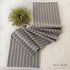 Striped Table Runner with Fringe on a dining table, showcasing its soft woven fabric and delicate white thread fringe detail.