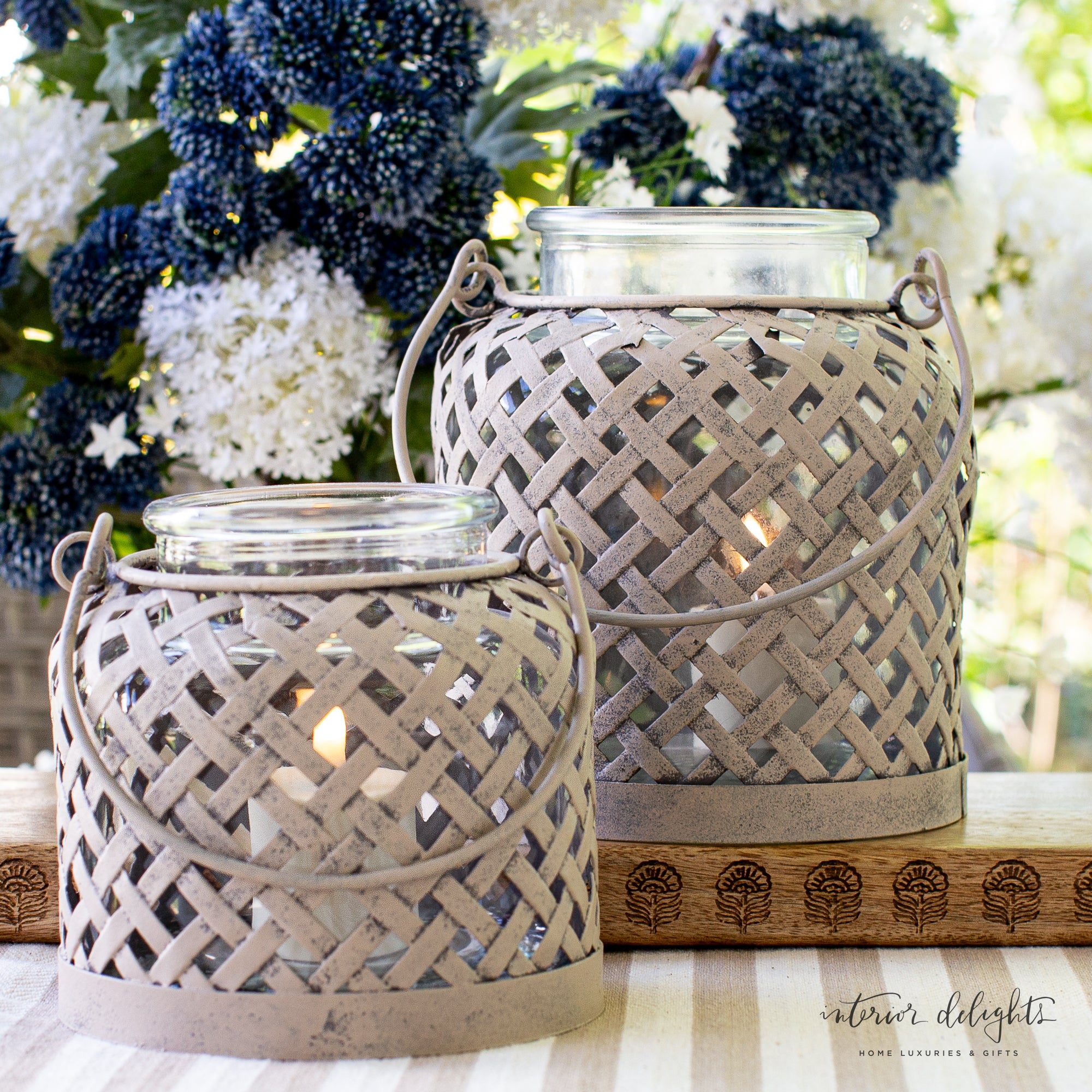 Lattice Lanterns: Set of 2 - Displaying the elegant beige lattice design of the lantern with a flickering candle inside.