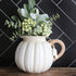 Charming white pumpkin pitcher with a twisted vine handle and leaf accent tag, perfect for fall decorating.