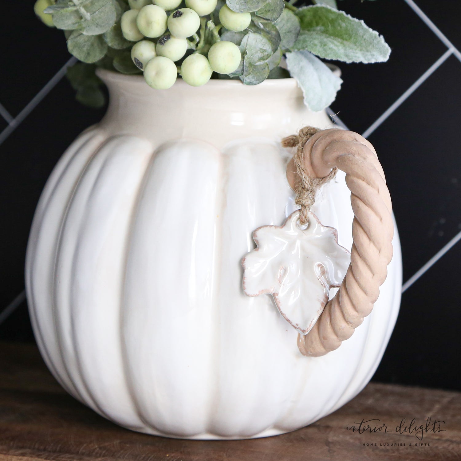 Decorative white pumpkin pitcher with twisted vine handle and leaf accent tag, perfect for fall decor.