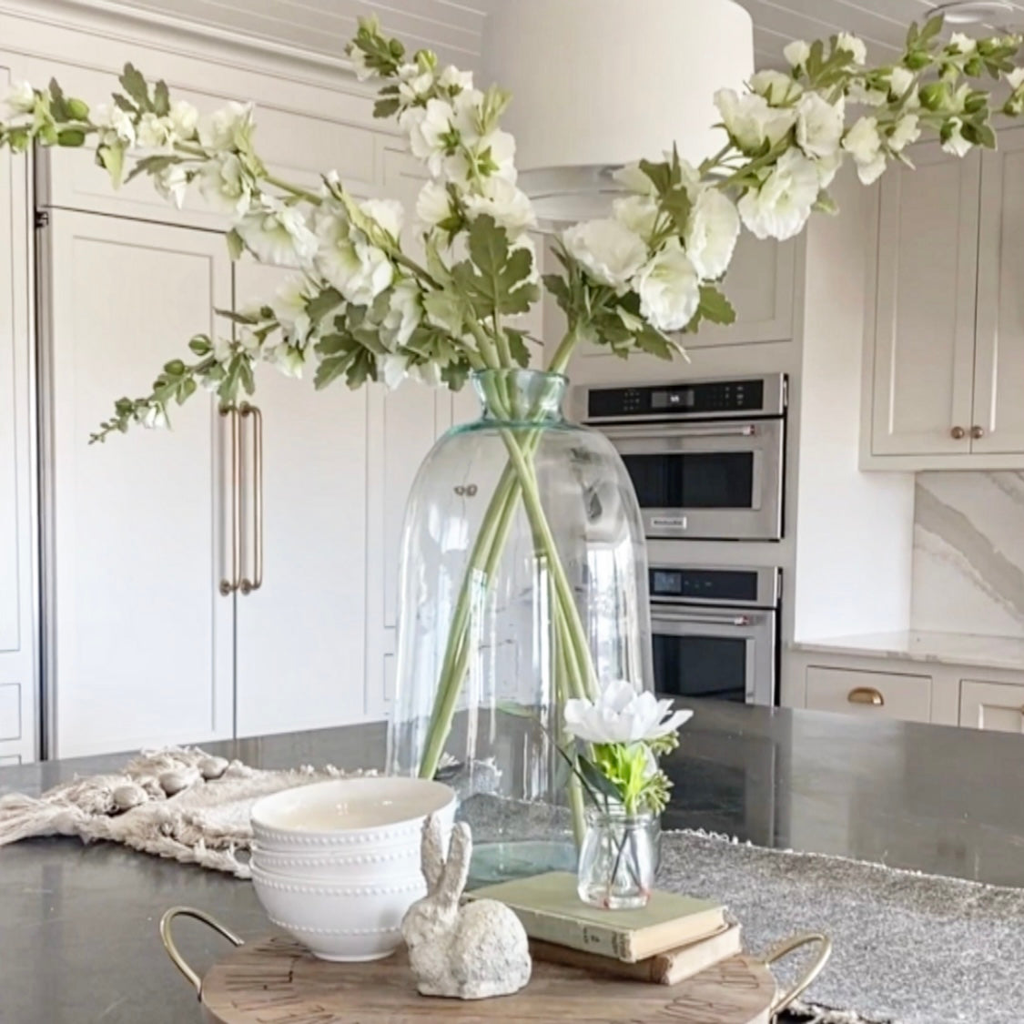 43" White Hollyhock Stem featuring tall lifelike blooms and flexible stems, perfect for spring home decor.