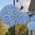 SUPERSAVINGS: Solar Nylon Blue burst Lanterns - 6 PACK glowing warmly in a garden setting, illuminating the evening.