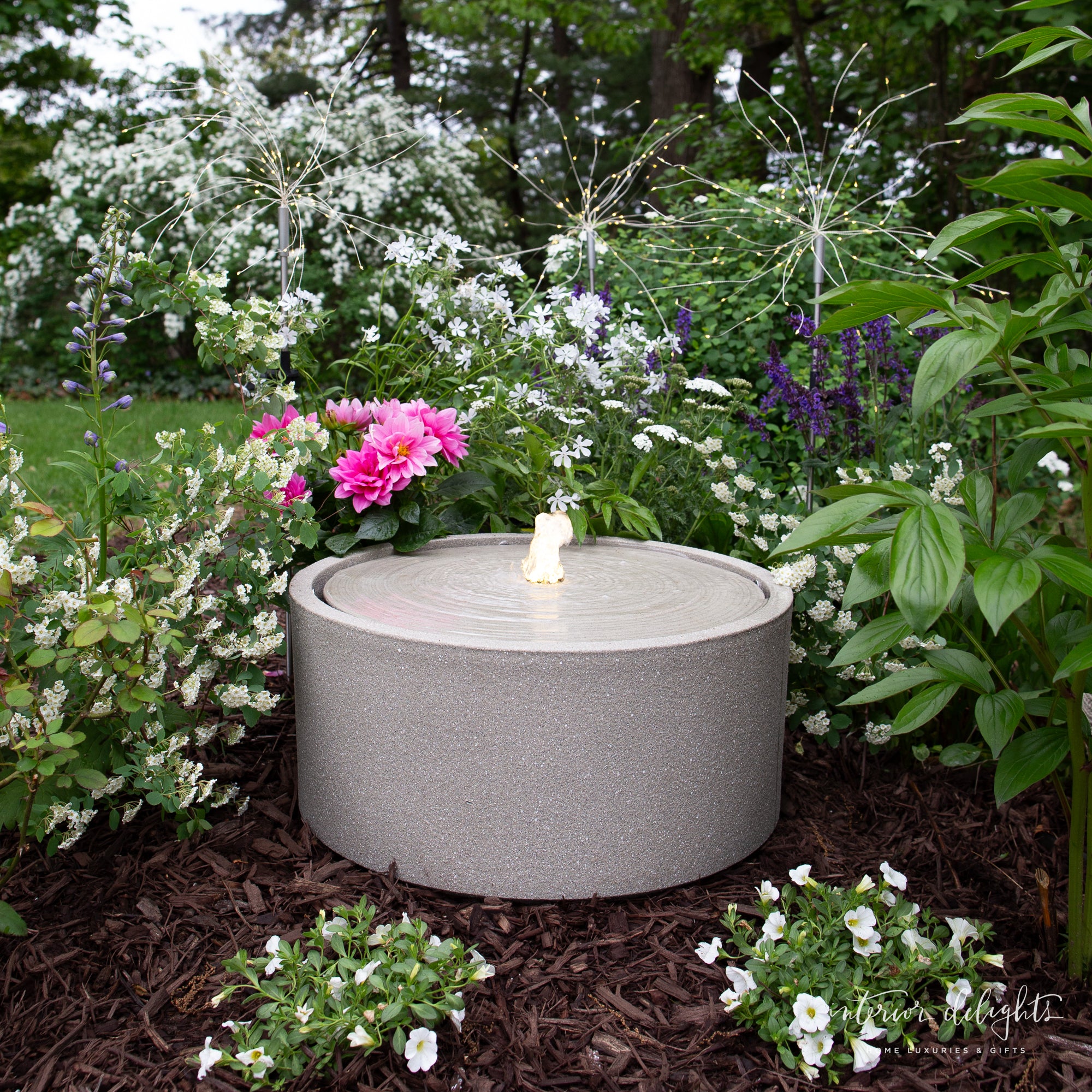 Dandelion Solar Stake Light in a landscaped garden setting, showcasing its solar-powered functionality and aesthetic charm.