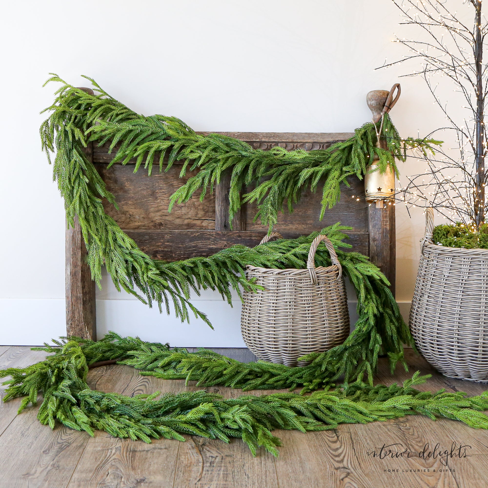 15ft Real Touch Norfolk Pine Garland displayed elegantly on a staircase railing, showcasing its realistic texture and lush greenery.
