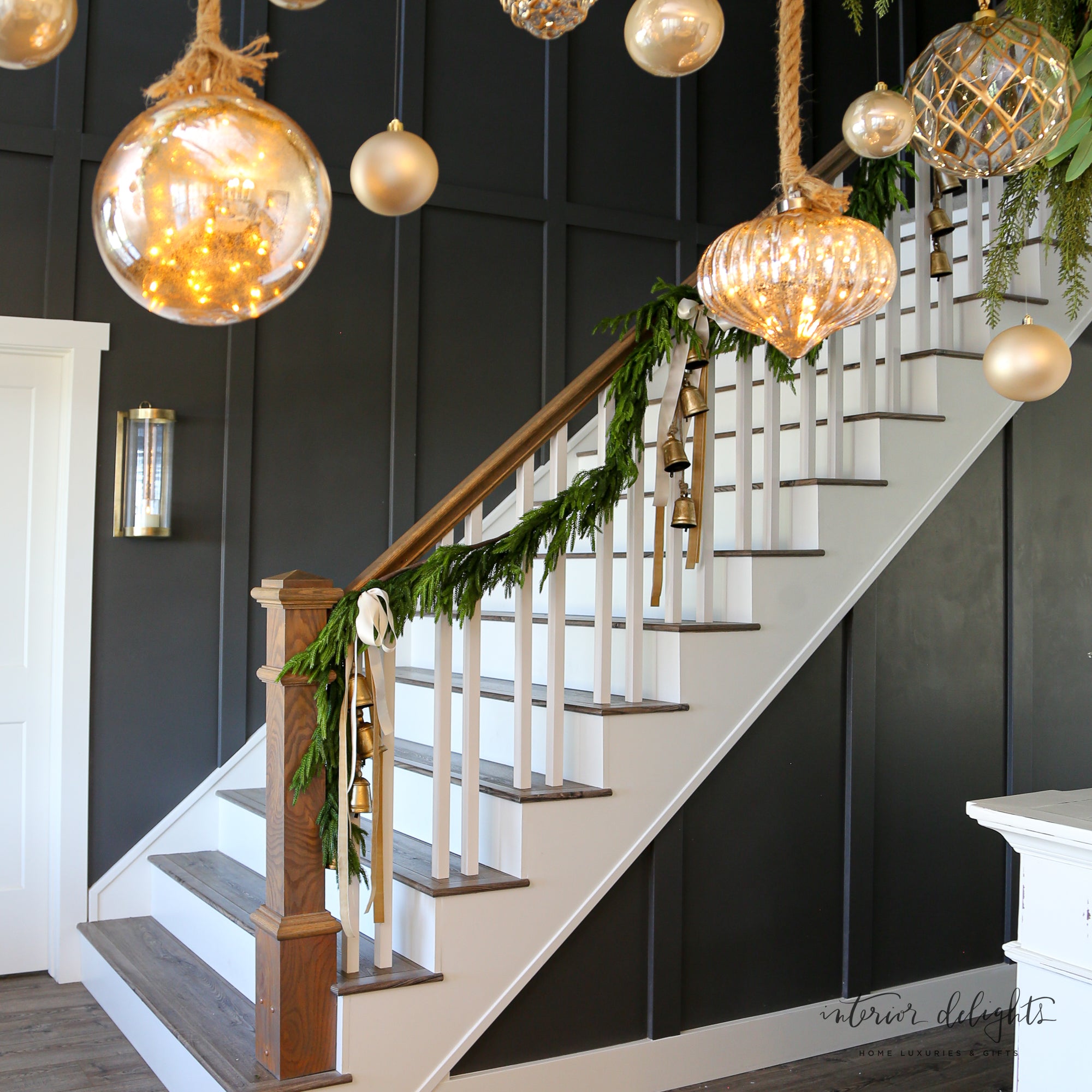 The 15ft Real Touch Norfolk Pine Garland hung on a doorway, demonstrating its versatility as a beautiful holiday decoration.