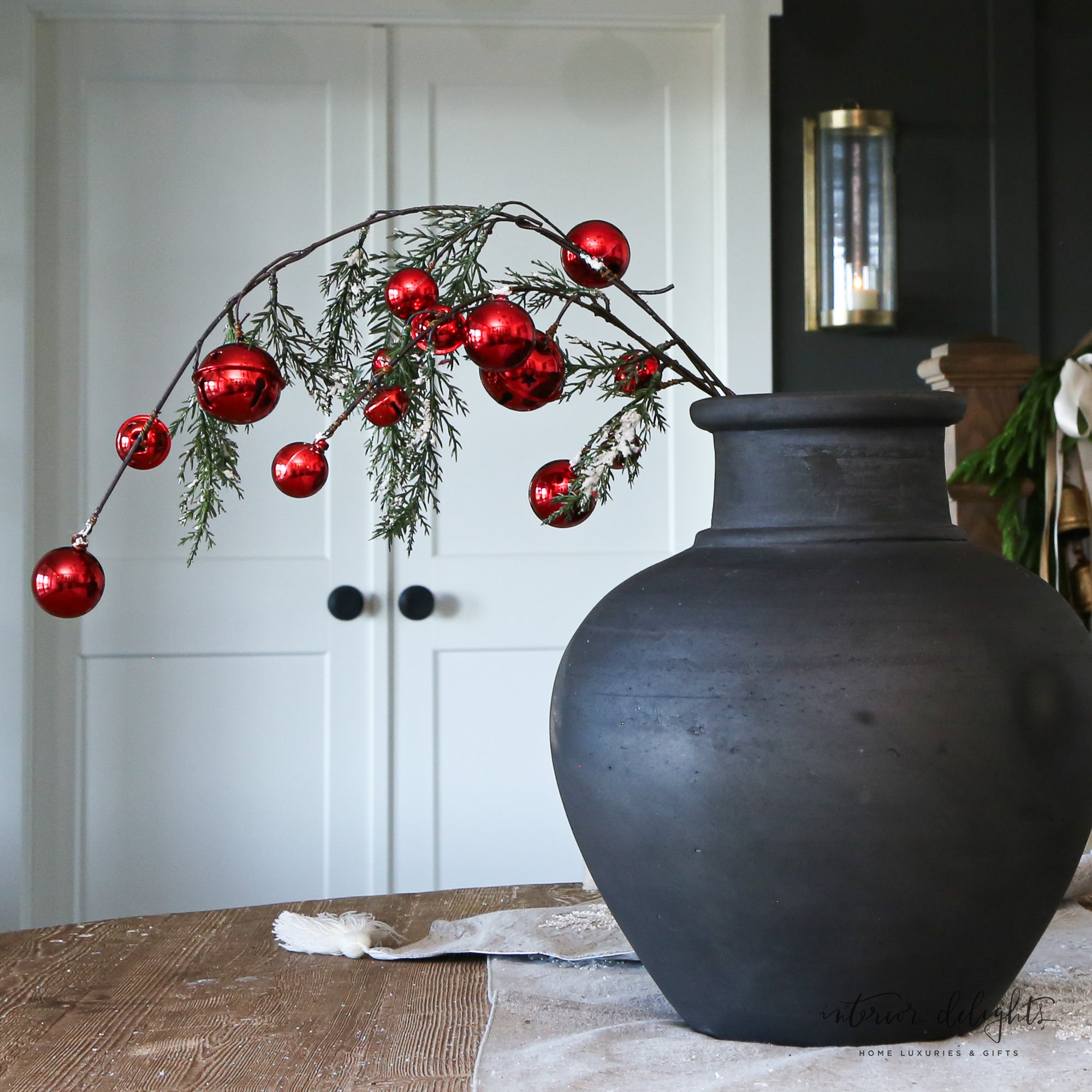Close-up of 35" Snowy Pine Branch With Red Bells showcasing lush greenery and festive red accents for Christmas decorations.