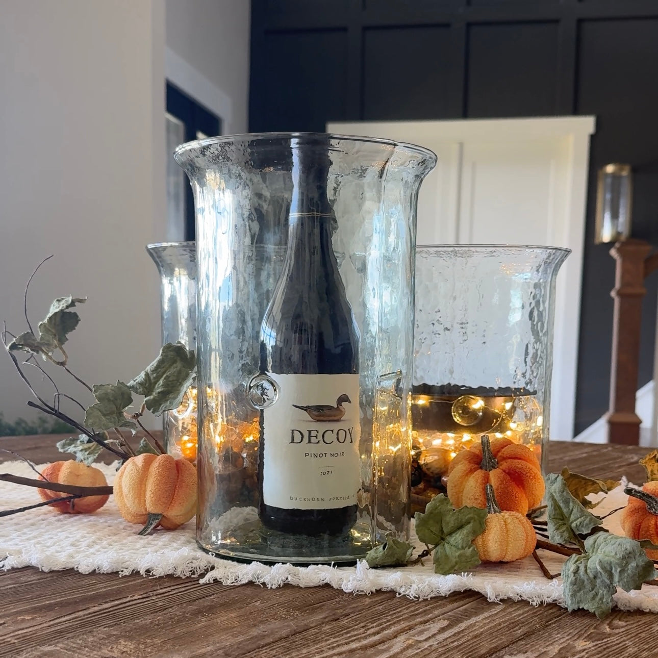 Medallion Hurricane Candle Holder in clear textured glass with dark rustic metal insert, perfect for seasonal decor all year round.