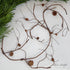 60" Twig and Pinecone Garland displayed on a rustic mantel, adding a charming touch to holiday decor.