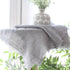 Lina Linen Runner in Warm Grey draped over a long rectangular table, showcasing its elegant design.