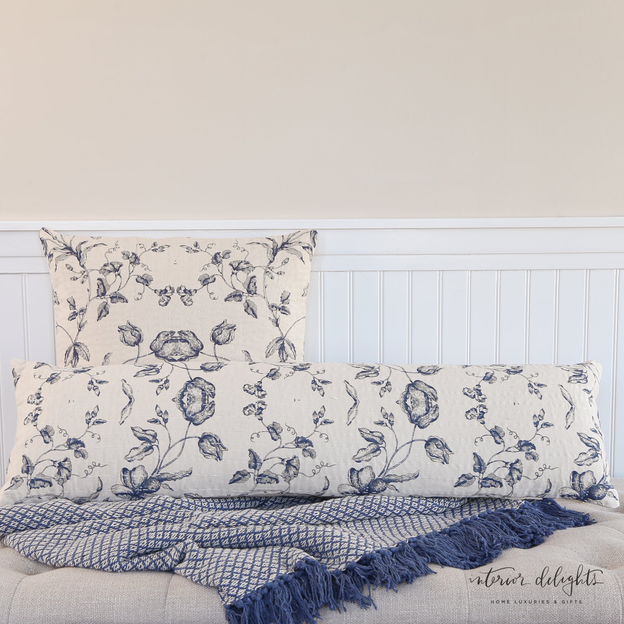 Cotton and Linen Square Pillow displayed on a bed, highlighting its vibrant blue floral pattern.