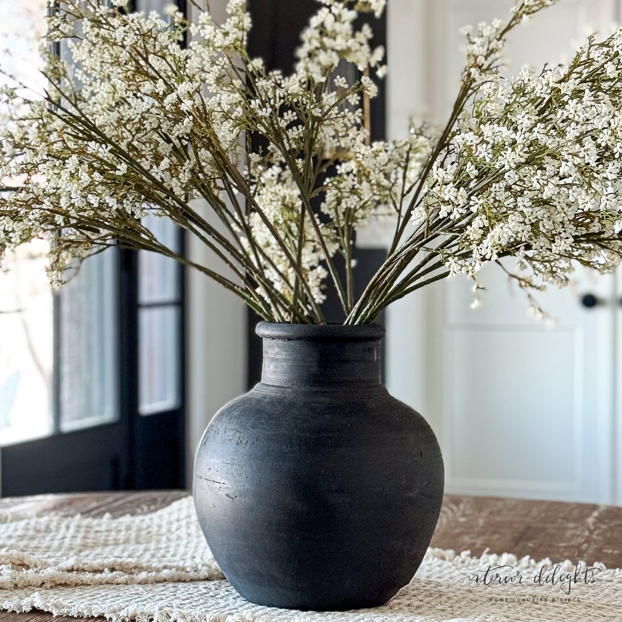 Beautifully arranged 13.5 in Black Terracotta Vase displaying tall, flowing floral arrangements.
