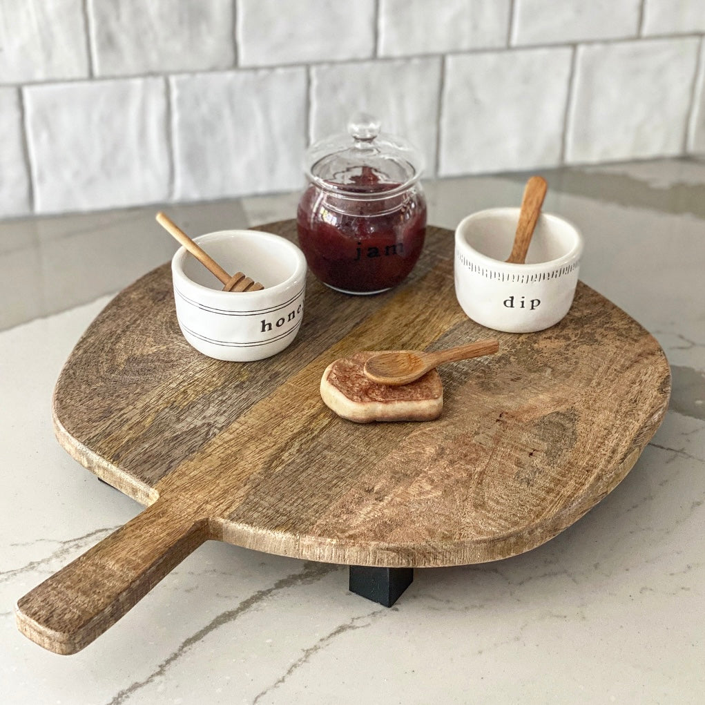 Lifestyle image of the Organic Shaped Round Board with Legs used as home décor in a stylish kitchen.
