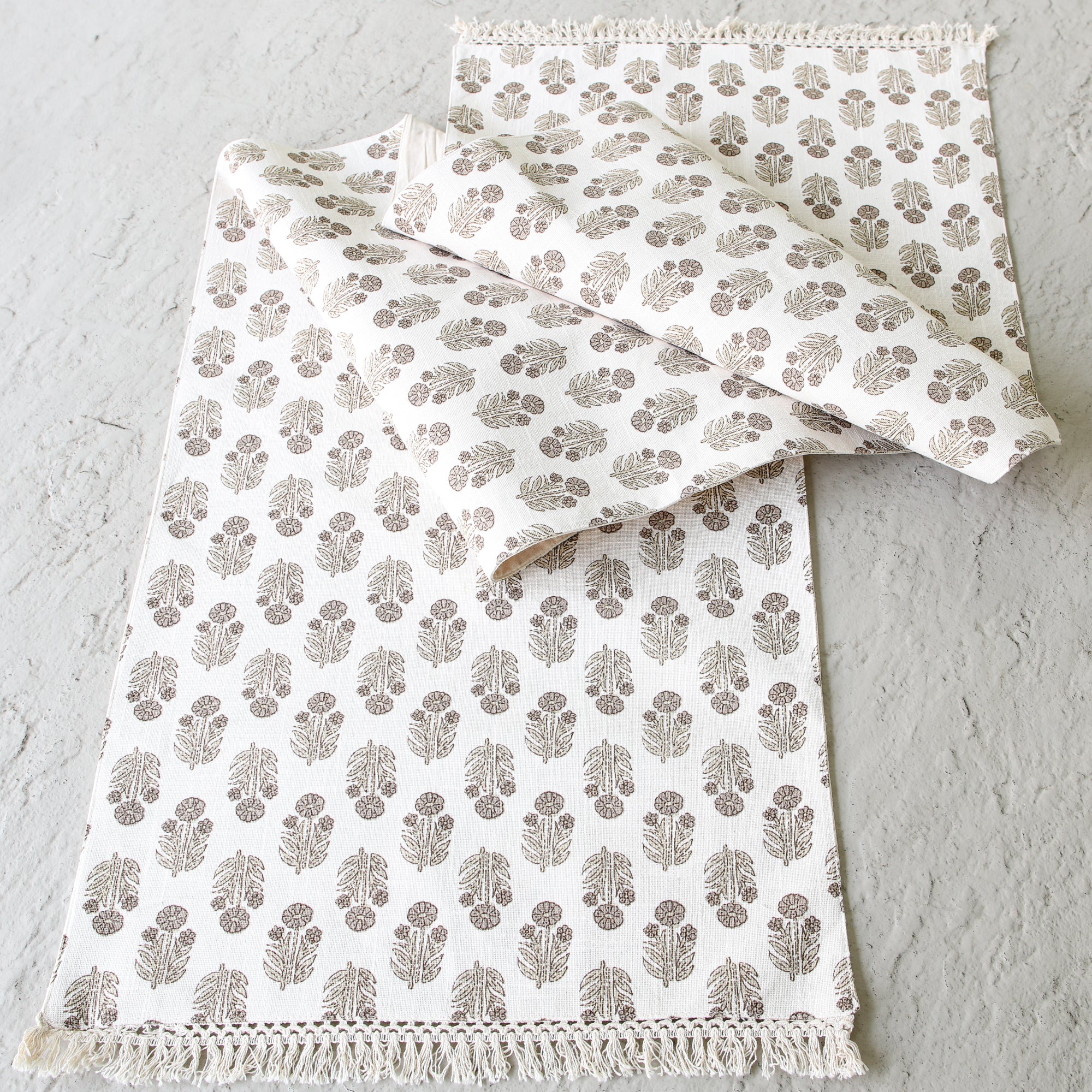 Taupe Block Print Table Runner displayed on a dining table with a soft fringe detail and intricate hand-stamped floral pattern.