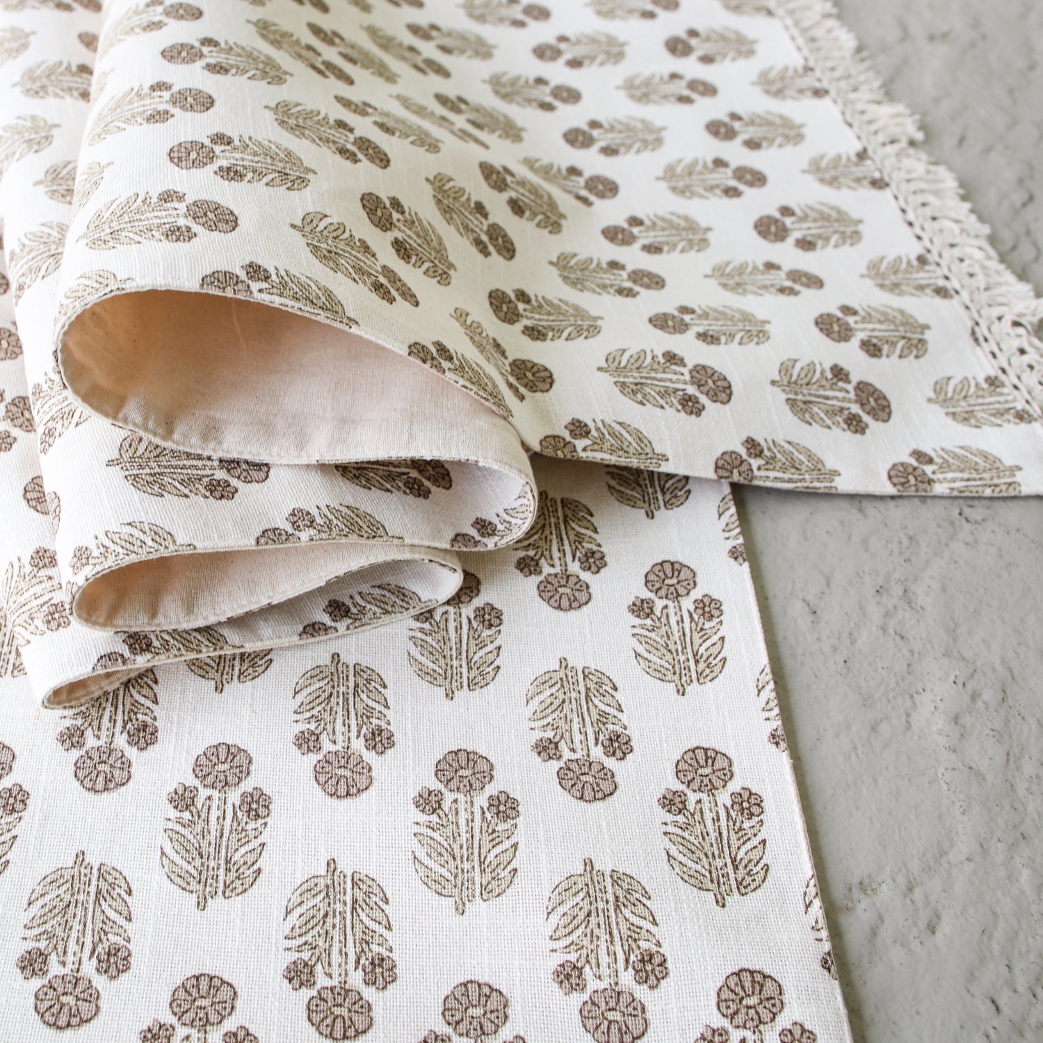 Taupe Block Print Table Runner with delicate hand-stamped floral design, showcasing its soft fringe detail.