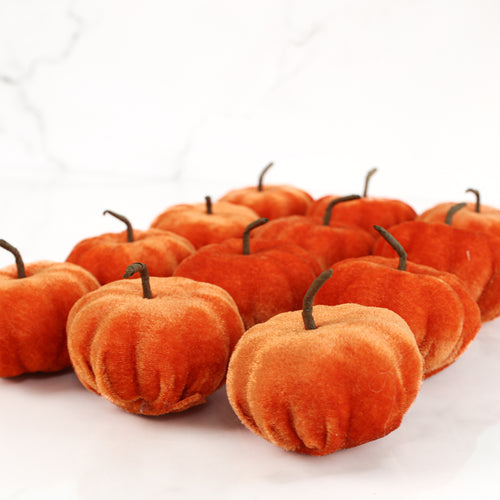 New England Orange Velvet Mini Pumpkins - Set of 12 displayed in a cozy autumn arrangement.