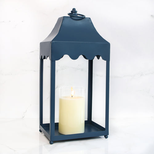 Stylish blue metal lantern with scallop detail, featuring a convenient loop top for easy hanging, ideal for displaying on a table or hook.