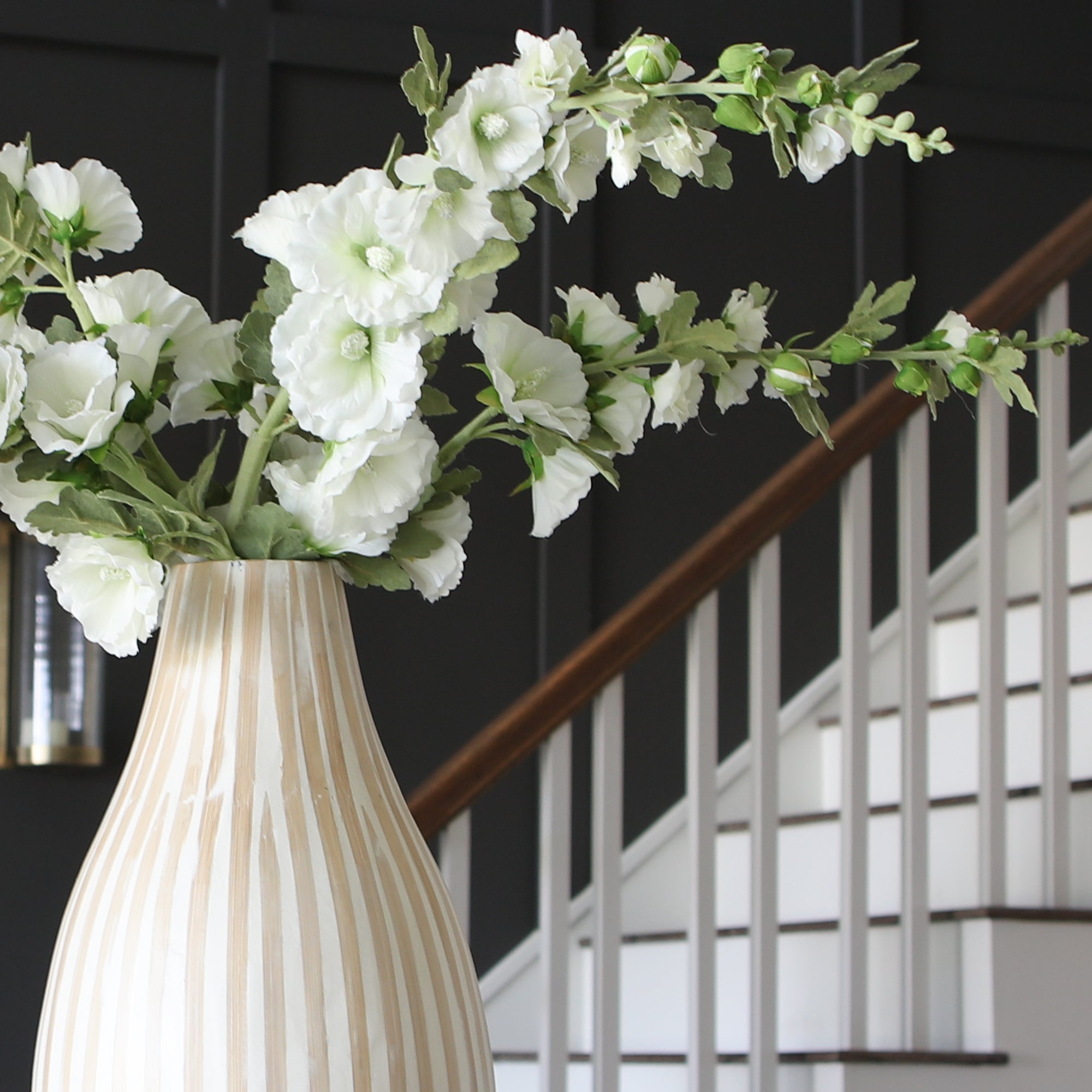 Close-up of the Hollyhock &amp; Large Striped Vase Arrangement highlighting the intricate details of the hollyhock blooms in a beautiful striped vase.