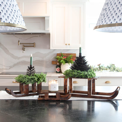 ARRANGEMENT: Sled Risers with Pinecones and Glitter Wreaths