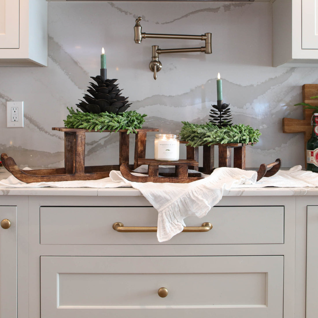 ARRANGEMENT: Sled Risers with Pinecones and Glitter Wreaths