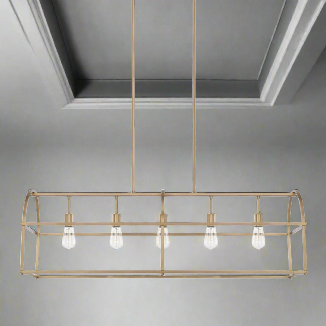 Molly - 5-Light Aged Brass Island Chandelier beautifully showcased over a dining table, adding elegant lighting and style to the space.