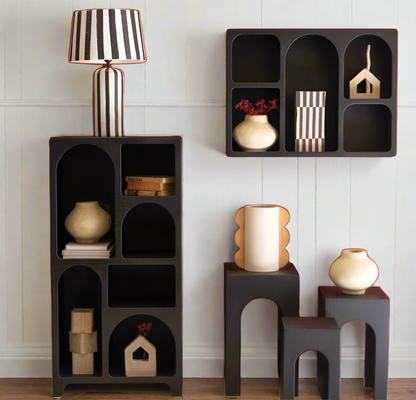 Black modular shelving units with decorative items on a white background