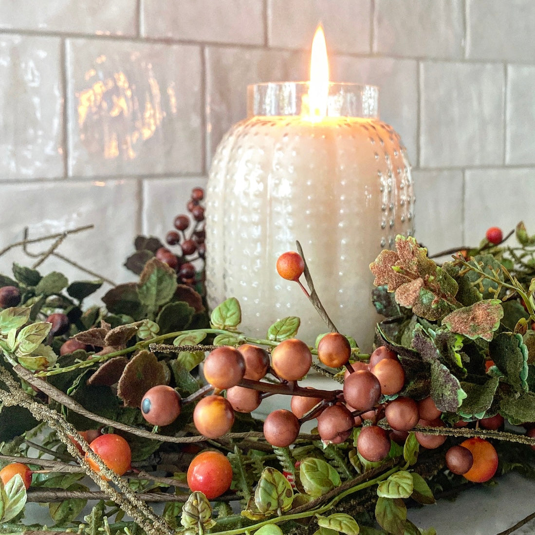 Burning Pumpkin Spice Candle in Pumpkin Hobnail Jar, creating a warm and inviting atmosphere indoors.