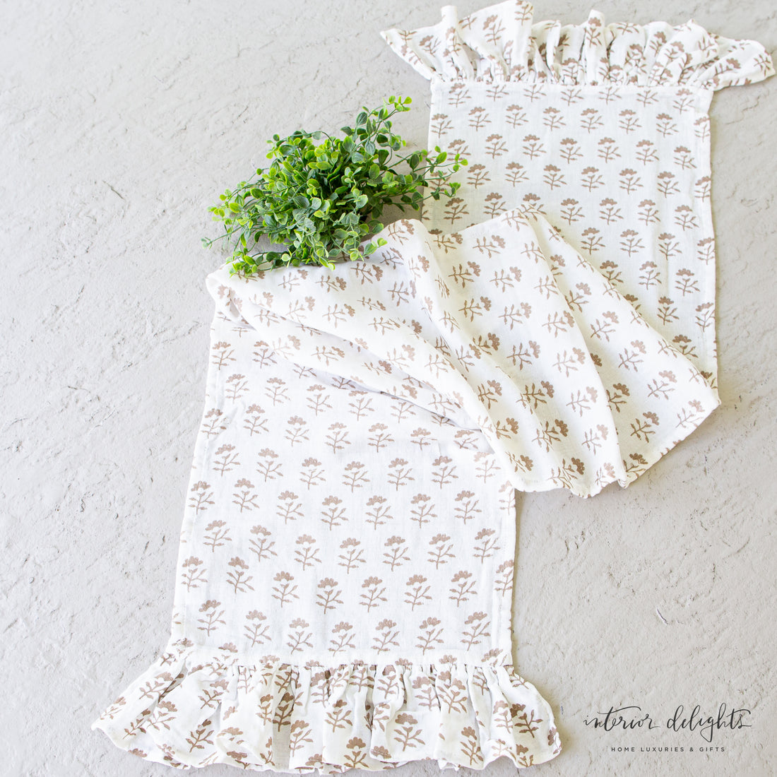Bundle of Two Molly Table Runners featuring a delicate light brown floral pattern and ruffled edges, perfect for layering during dining or gatherings.