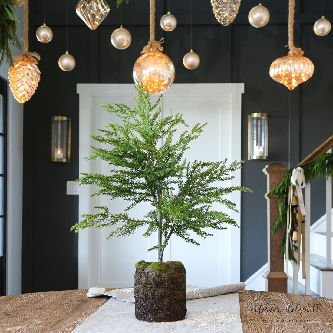 Close-up of the 24” Spruce Tree showcasing lifelike leaves and mossy base ideal for enhancing indoor spaces.