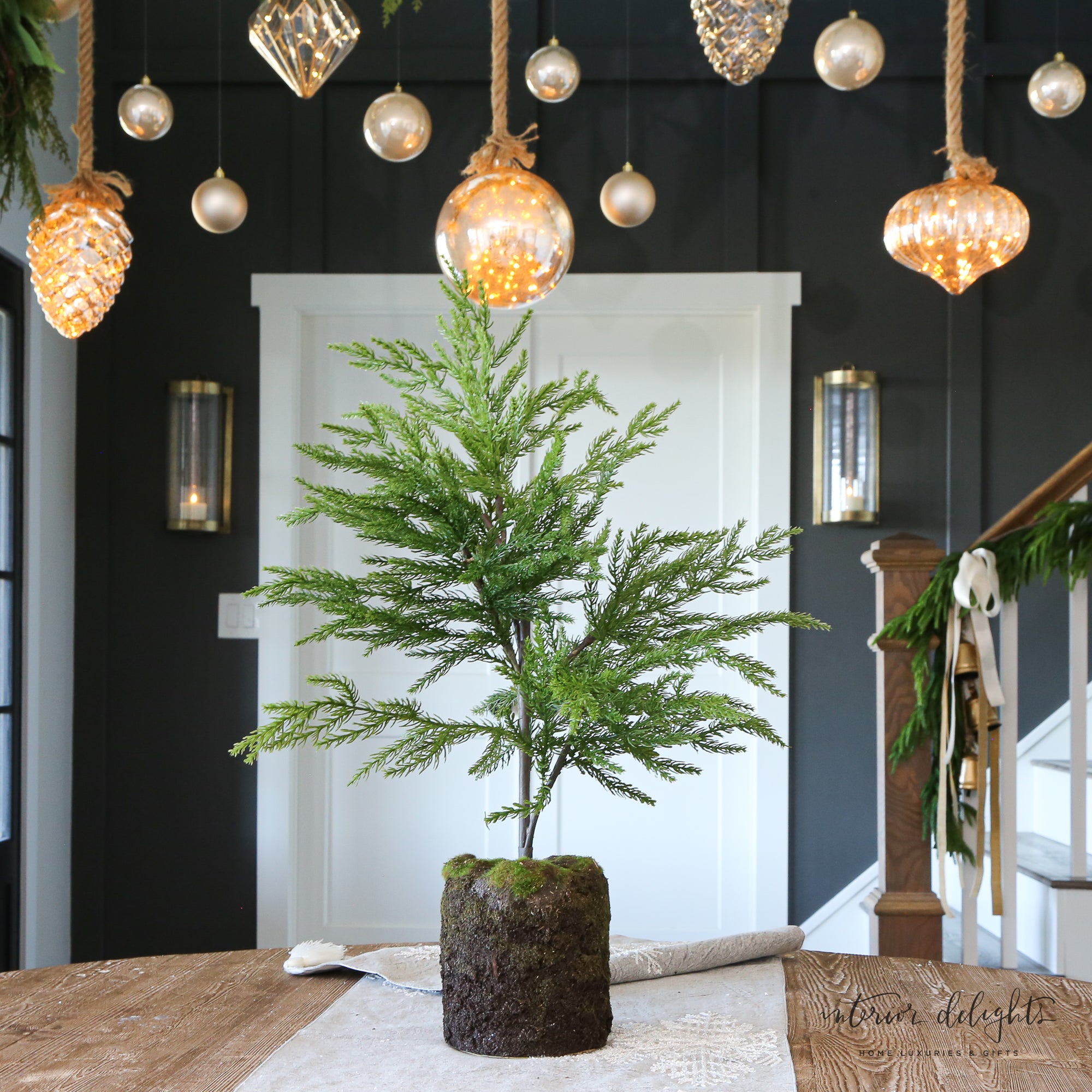 Close-up of the 24” Spruce Tree showcasing lifelike leaves and mossy base ideal for enhancing indoor spaces.