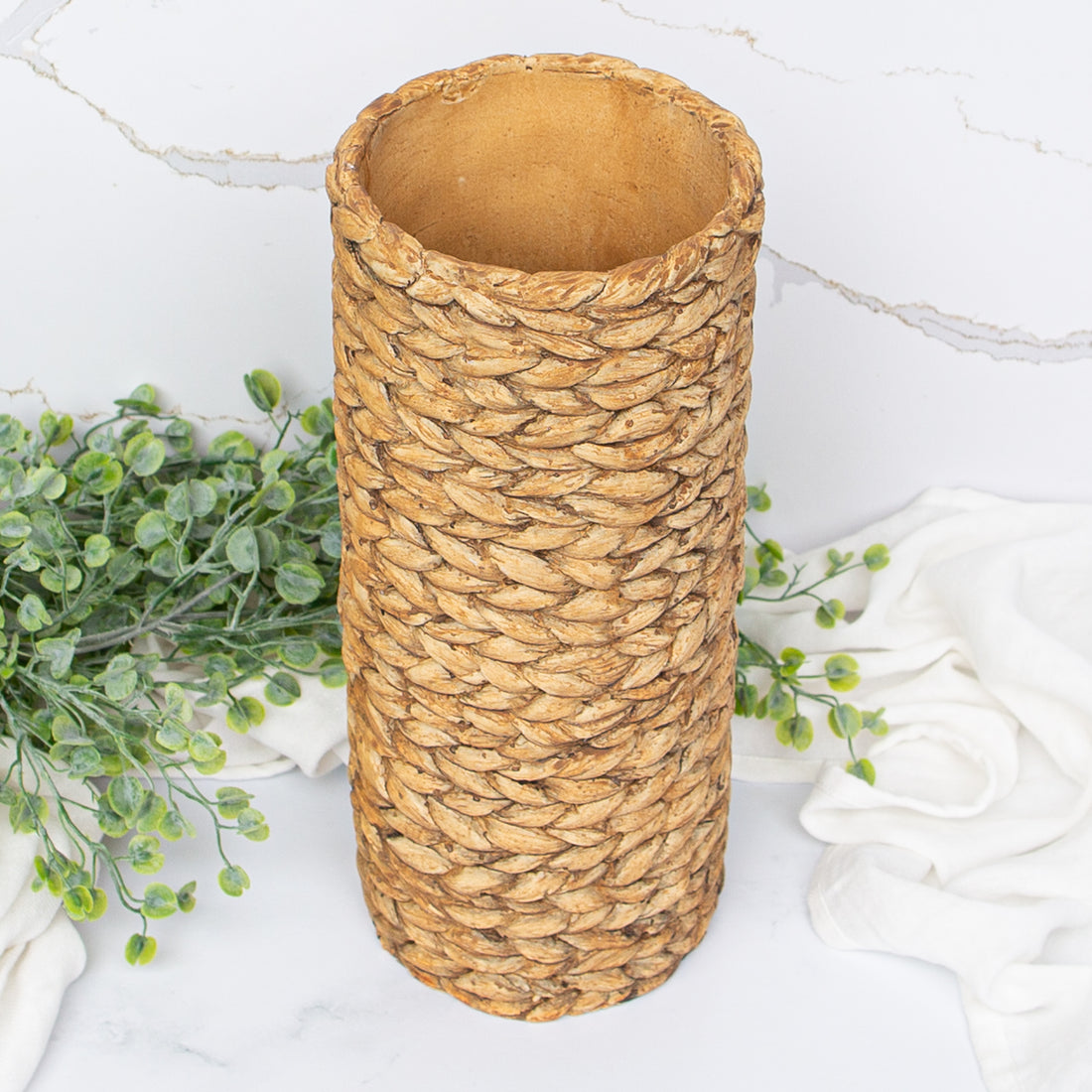 The 12.5&quot; Tan Braided Pattern Cement Vase displayed with orange Gerber daisies, creating a lively home decor scene.