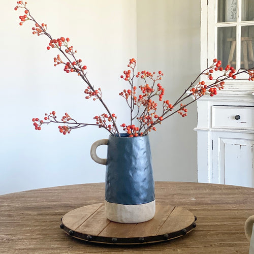 48" Orange Berry Spray displayed in a stylish arrangement with ceramic vases and a lazy susan.